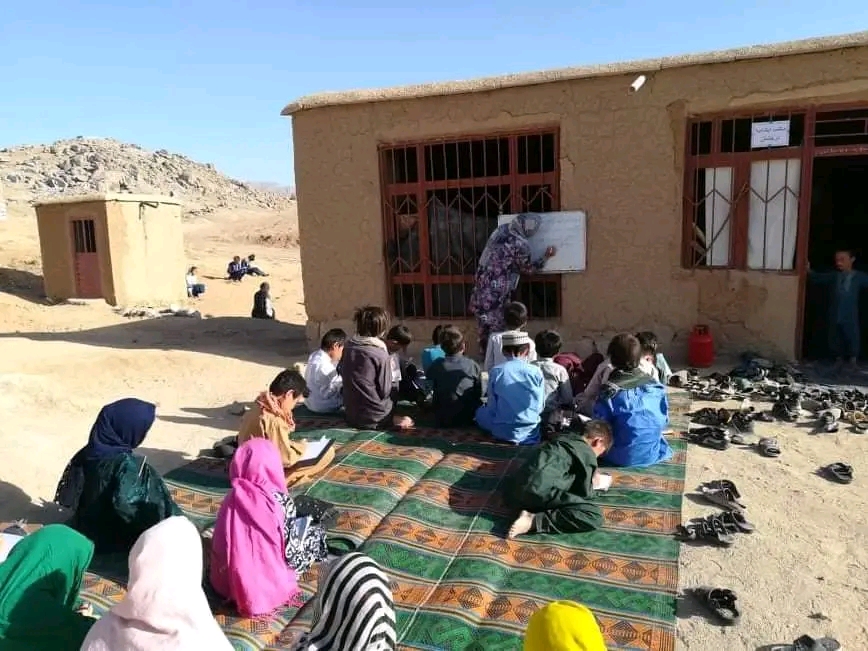 یک خبرنگار زن در دایکندی به گونه ی رضاکار به کودکان مهاجر تدریس می‌کند